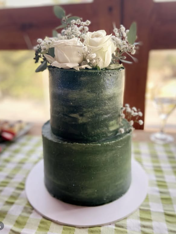 Two-tier deep green watercolour cake with white roses and baby's breath